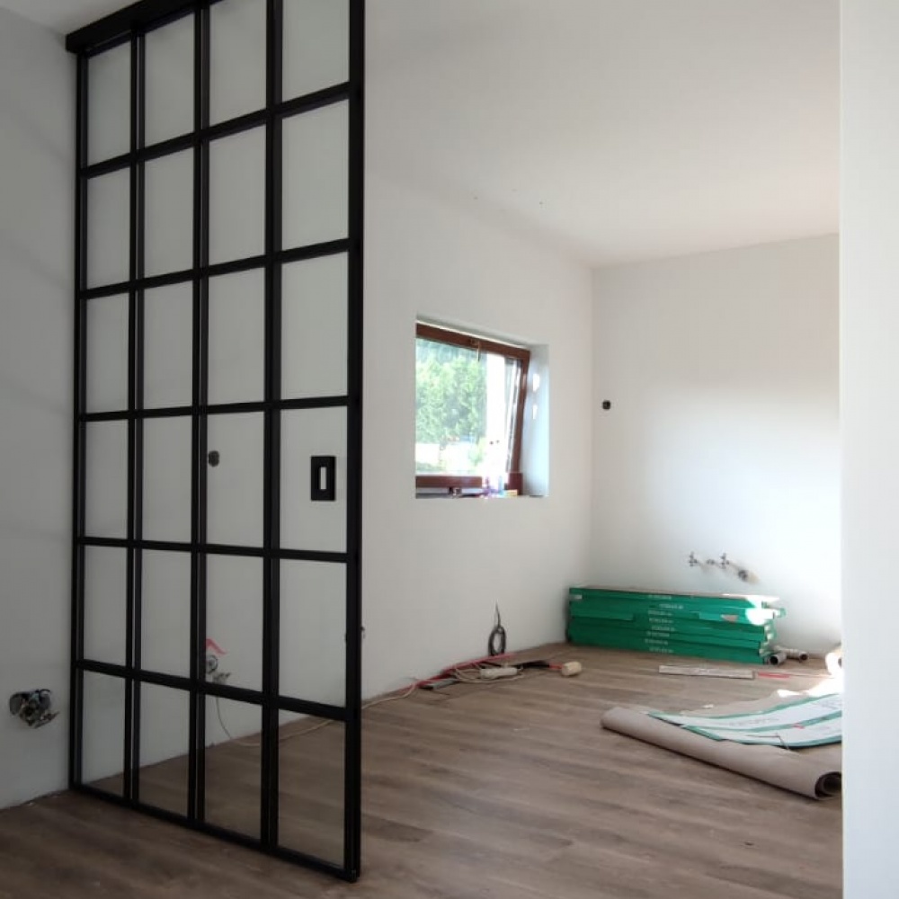 Rámové sklenené posuvné dvere, navrhnuté pre klienta na mieru. Čierny dizajn, bezbárierový prechod, podkonštrukcia navrhnutá skúseným technikom.